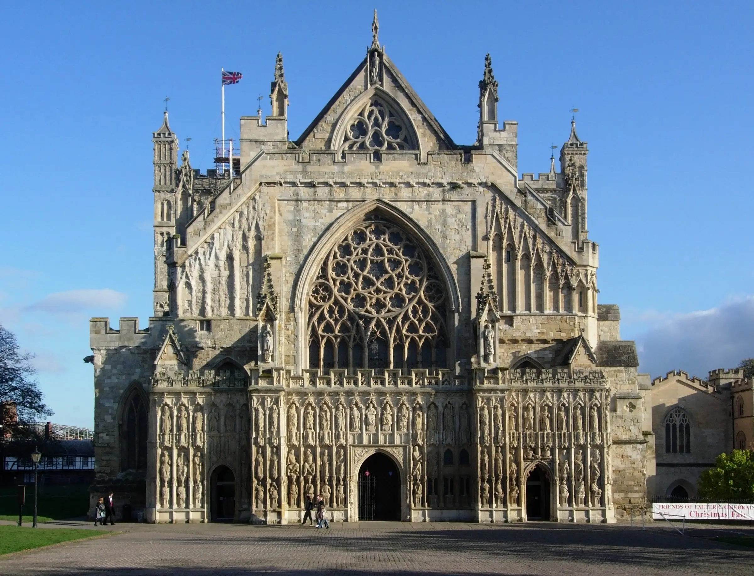 The west front of Exeter Cathedral, its carved stone screen and great window in afternoon sun