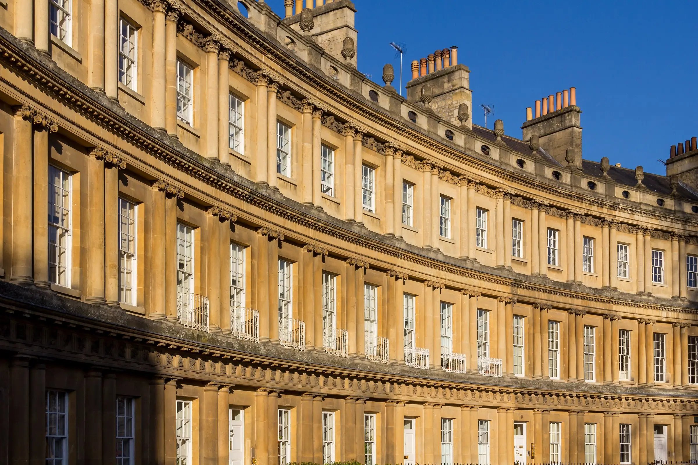 The Royal Crescent in Bath, its Georgian stone facade in low golden light
