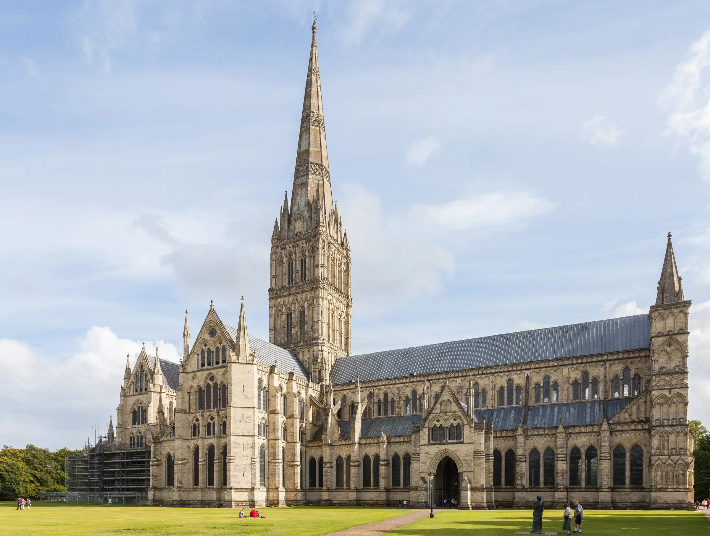 Salisbury Cathedral and its spire seen across the lawn of the Cathedral Close on a bright day